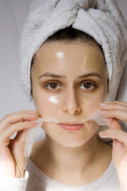 A woman removing a facial mask at a spa.