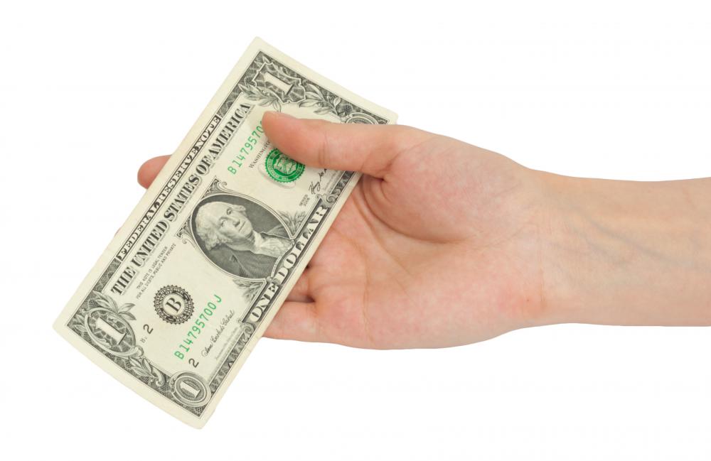 A person tipping a waiter at the front of the house.