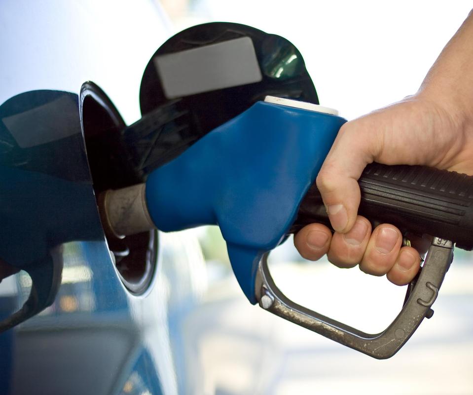 A man filling up his car with gasoline. A higher demand for gas can lead to higher oil prices.